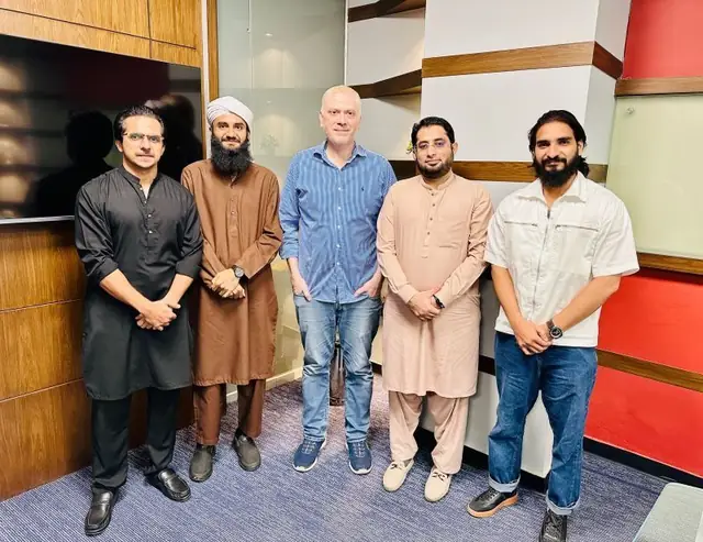 Five professionals standing together in a modern office