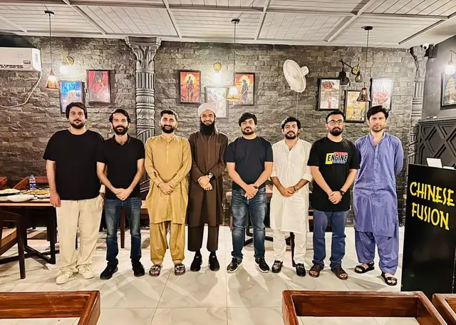 Eight community members standing in a row at a restaurant
